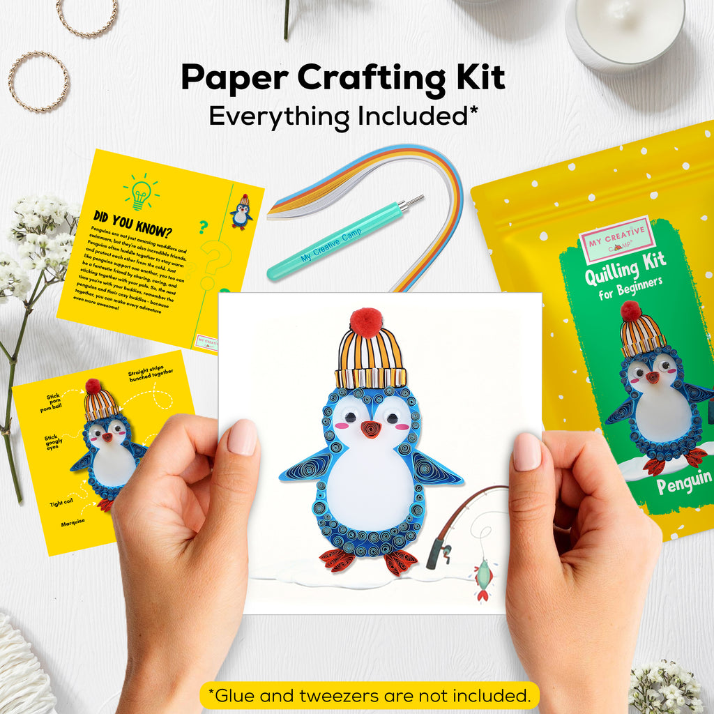 Paper crafting kit with penguin design, including cards and a completed craft, on a white surface.