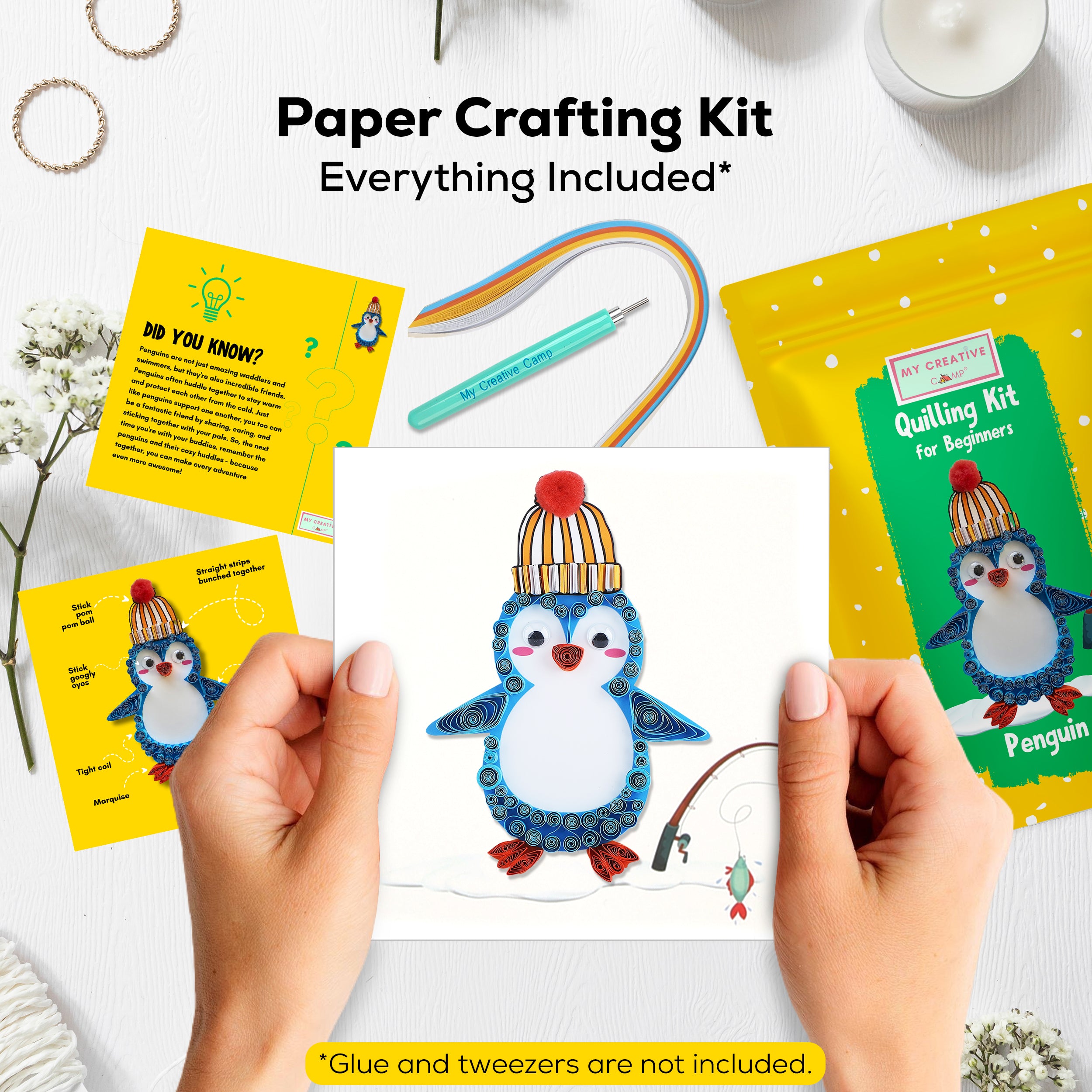 Paper crafting kit with penguin design, including cards and a completed craft, on a white surface.