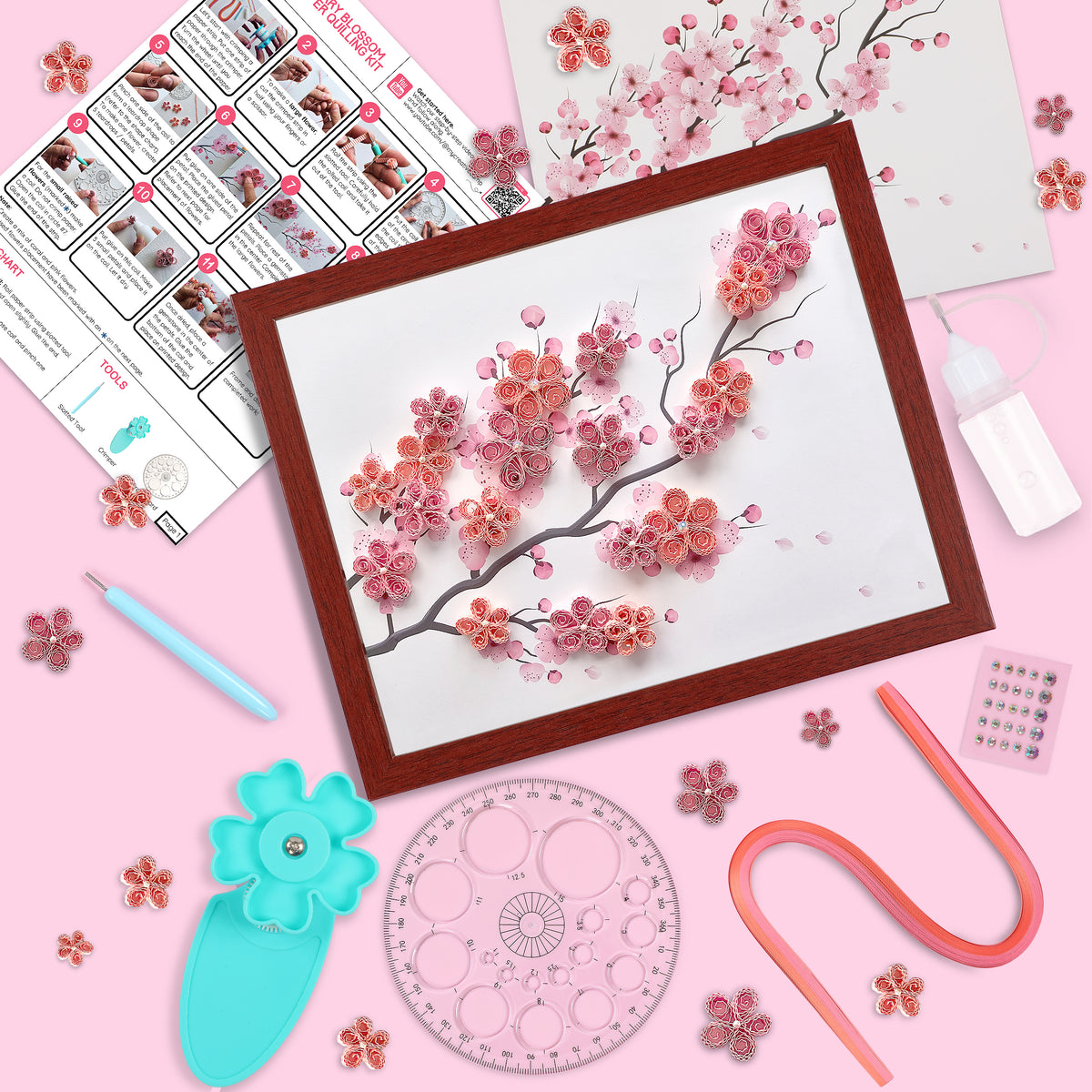 Artistic craft project with cherry blossom design, tools, and materials on a pink background