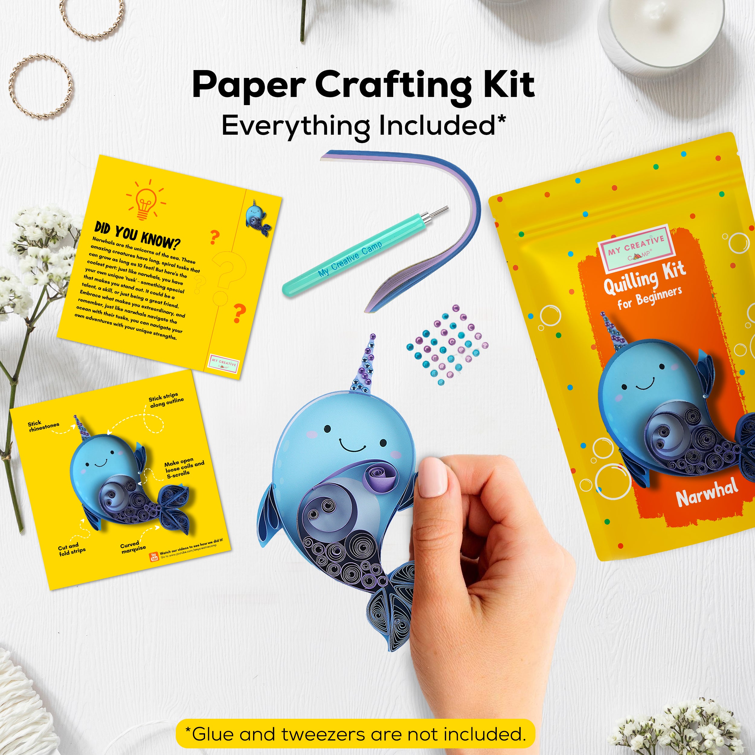Paper crafting kit with a narwhal model, cards, and tools on a white background
Hands creating a narwhal paper quilling artwork using an intermediate DIY craft kit