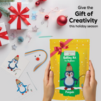 Quilling kit for beginners with penguin design, surrounded by Christmas decorations on a white background.