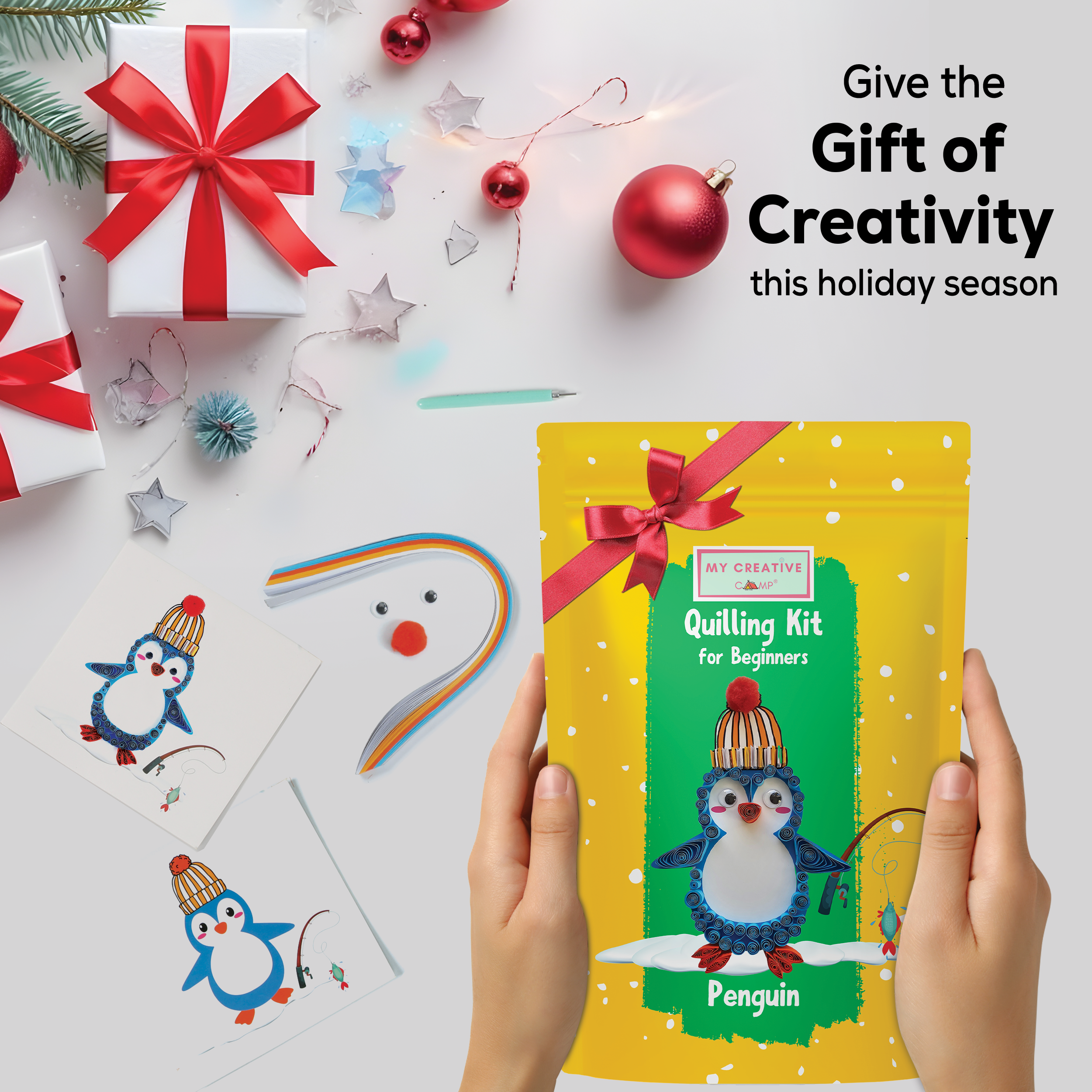 Quilling kit for beginners with penguin design, surrounded by Christmas decorations on a white background.
