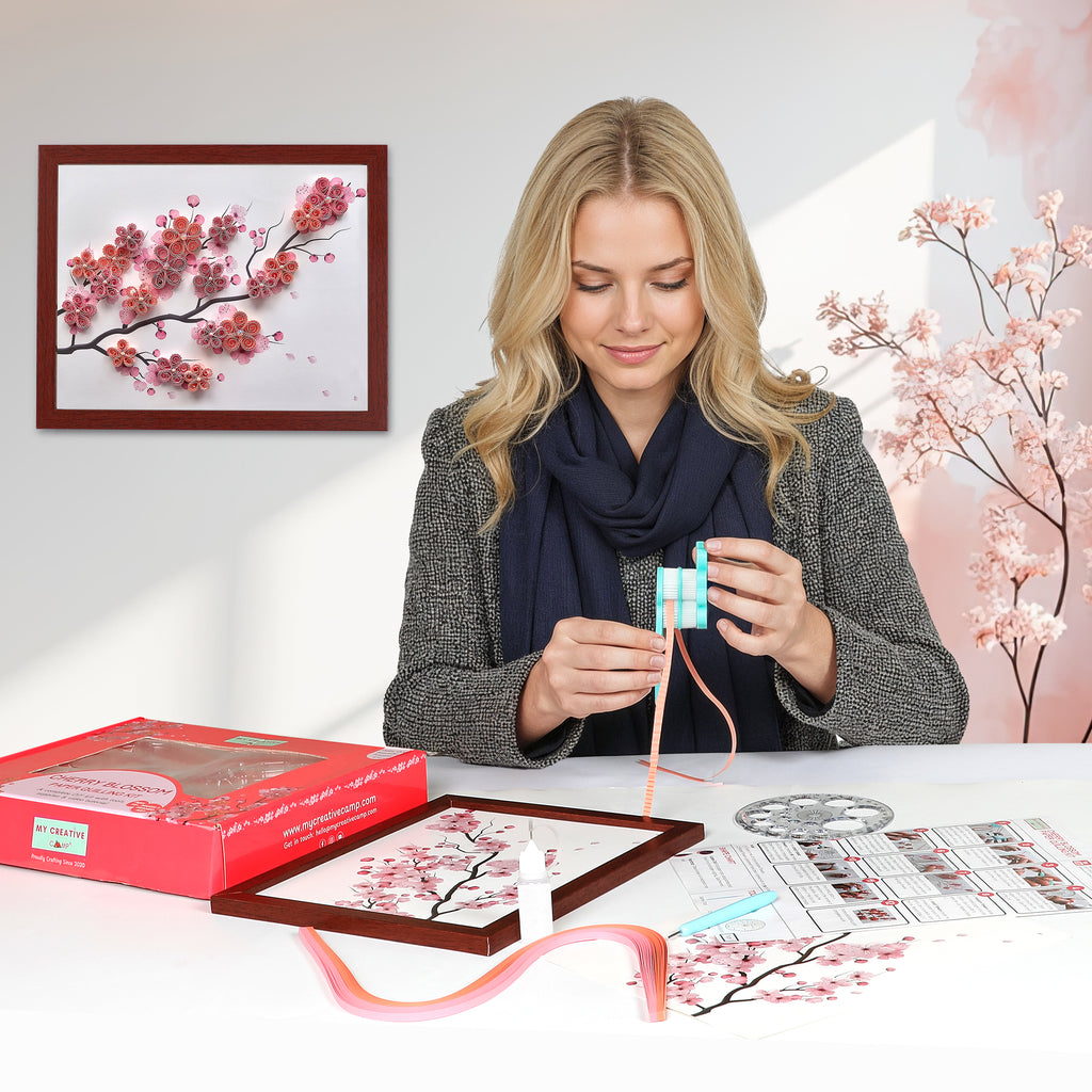 Woman working on a craft project with cherry blossom-themed materials and decorations.