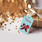 Gift with a blue tag featuring a red butterfly design and 'Happy Holidays' text, surrounded by gold confetti.
Handmade gift tag decorated with paper quilling flowers and embellishments