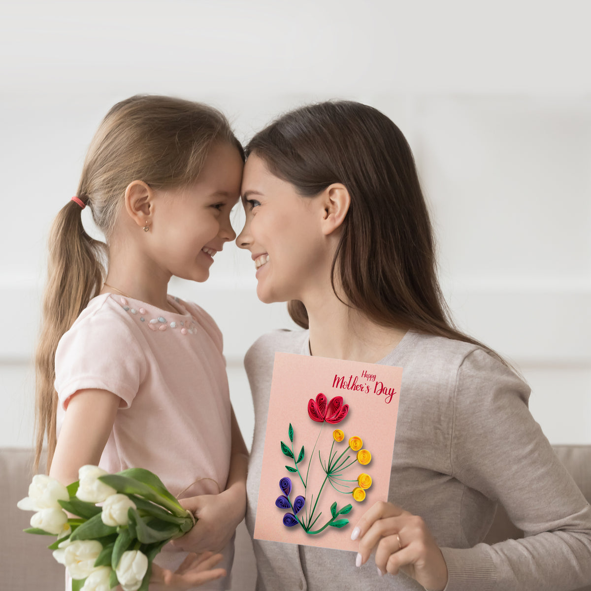Mother and child holding a handmade greeting card created with a paper quilling kit